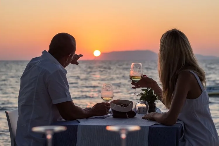 Couple enjoying sunset dinner in Thailand — retirement lifestyle